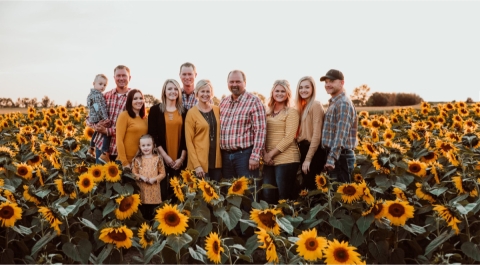 The Lewis family posing for pictures in a field of sunflowers.